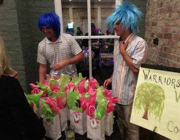 Photo of 2 men with blue wigs giving away gift baskets at a charity event for United MSD Foundation
