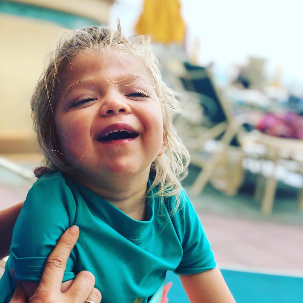 A young child with MSD named Willow laughing at Beach