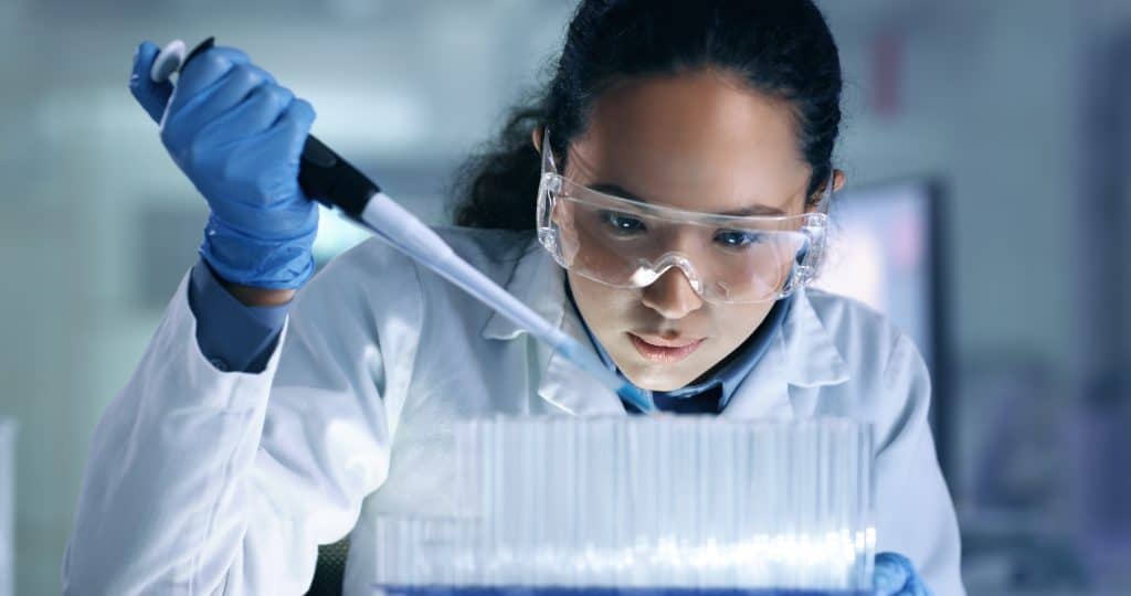 Research, experiment and trial being done by a scientist in a lab, science facility or hospital. One young, serious and professional medical researcher organizing, sorting or making a discovery